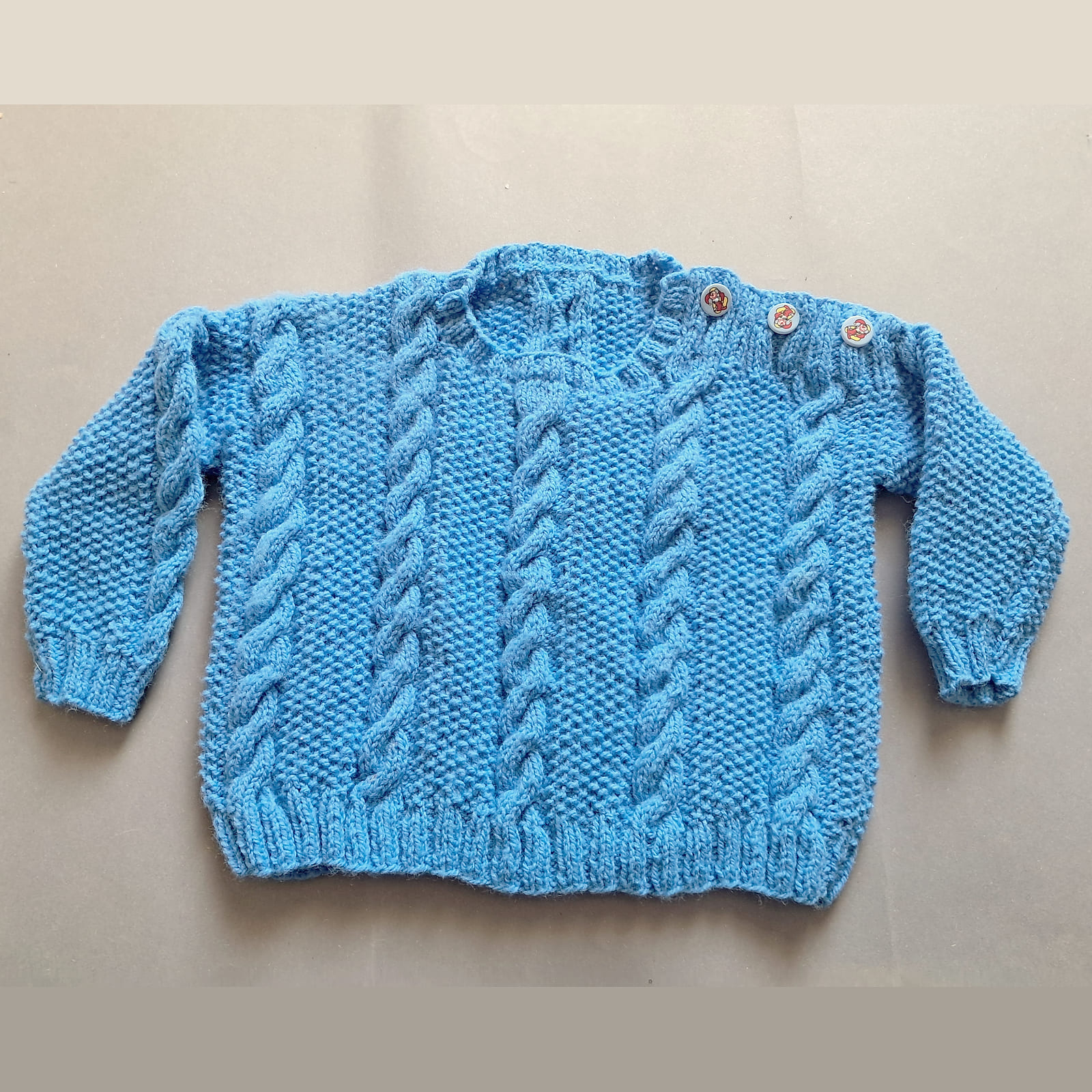 Modrý pulóvrik s vrkočmi